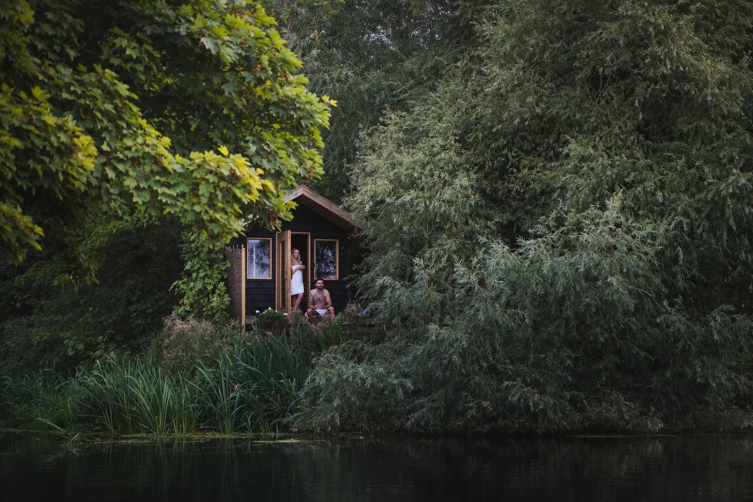 The wood-fired Secret Sauna cabin among trees on the River Waveney